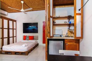 a bedroom with a bed and a kitchen with shelves at La Puerta Roja Guest House in Santo Domingo