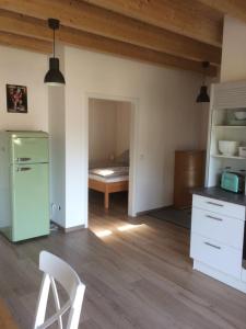 a kitchen with a green refrigerator and a bedroom at Die Pfalzherberge in Waldfischbach-Burgalben