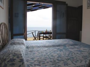 una camera da letto con un letto e vista sull'oceano di Isola d'Elba Come in Barca, a un Tuffo dal Mare a Capoliveri