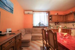 uma cozinha e sala de estar com um sofá e uma mesa em Apartment Lile em Kuciste
