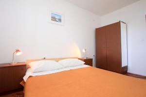 um quarto com uma grande cama laranja e um armário em Apartment Lile em Kuciste