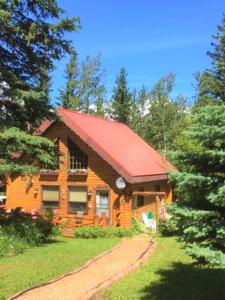 uma cabana de madeira com um telhado vermelho em The Gingerbread Cabin em Jasper
