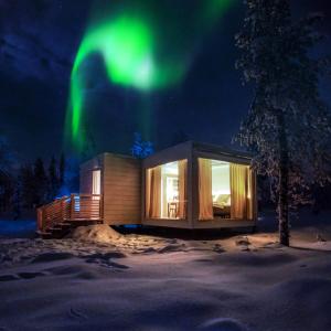 une cabine avec les lumières du nord dans le ciel dans l'établissement Northern Lights Ranch, à Levi