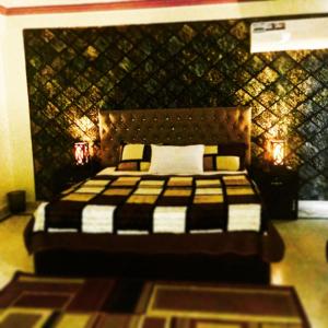 a bedroom with a large bed with a wall at Muzaffarabad View Motel in Muzaffarabad