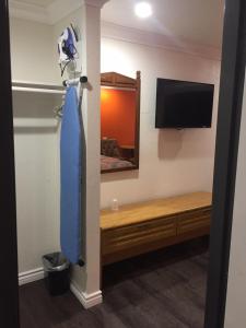 a room with a bed and a tv and a blue umbrella at Welcome Inn & Suites Anaheim in Anaheim