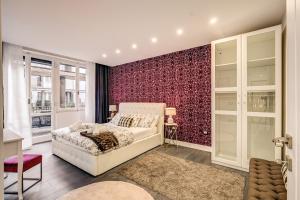 a bedroom with a white bed and a red wall at AwesHomeItaly - Hanging Gardens in Pisa