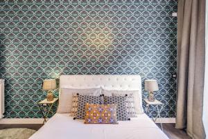 a bedroom with a bed with a blue and white wallpaper at AwesHomeItaly - Hanging Gardens in Pisa