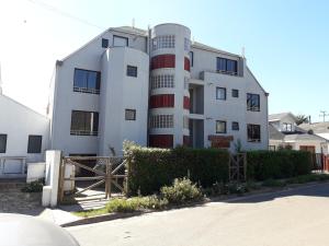 a white building with a fence in front of it at Maitencillo Habitamar in Maitencillo