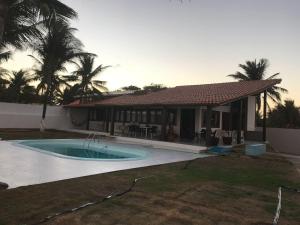 a house with a swimming pool in the yard at Casa da Barra in Barra de São Miguel