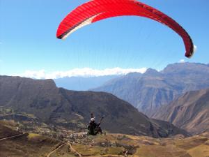a person flying a parachute over a mountain valley at La Mansion Casa Hotel in Andahuaylas