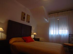 a bedroom with a bed with a red pillow on it at Bungalow Arenales del Sol, Alicante in Arenales del Sol +50 photos