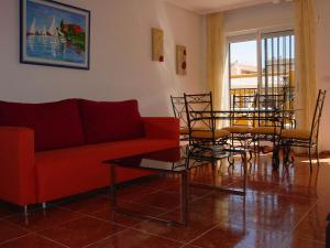 a living room with a couch and a table and chairs at Bungalow Arenales del Sol, Alicante in Arenales del Sol