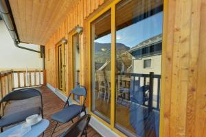 een balkon met 2 stoelen, een tafel en een raam bij Jacobs Resort House Kranjska Gora in Kranjska Gora