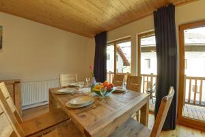 a dining room with a wooden table and chairs at Jacobs Resort House Kranjska Gora in Kranjska Gora