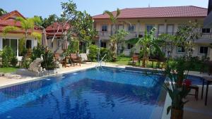 a swimming pool in front of a house at Baan Sooksiri Bangsaray in Bang Sare