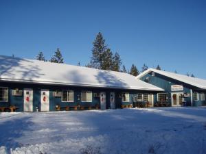 um edifício azul com neve em cima em White Willow Motel em Fruitland