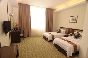 Cette chambre comprend deux lits et une télévision. dans l'établissement Seemsoon Hotel, à Ipoh