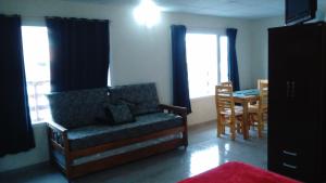 a living room with a couch and a table and windows at Apartamentos Croacia del Mar in Santa Clara del Mar