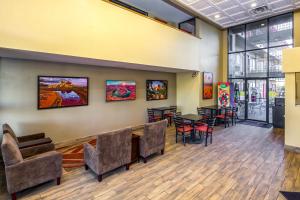 uma sala de espera com mesas e cadeiras e pinturas na parede em Travelers Inn - Phoenix em Phoenix