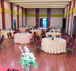 a banquet hall with white tables and chairs at Revayah Hotels in Ruteng