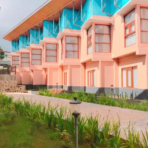 ein rosa und blaues Gebäude mit einem Straßenlicht davor in der Unterkunft Revayah Hotels in Ruteng