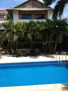 a swimming pool in front of a house with palm trees at Hotel Boutique Casa Berastegui in Puerto Colombia