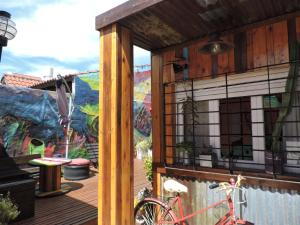 a bike parked on a wooden deck with a mural at Carrusel Art-Hostel in Mar del Plata