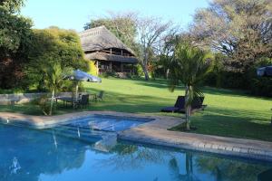 a house with a swimming pool in the yard at Kumbali Country Lodge in Lilongwe