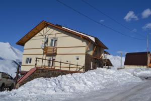 a house with snow on the ground in front of it at Gio Hotel in Gudauri