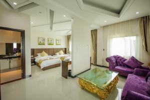 Habitación de hotel con cama y sala de estar. en Jing Pin Hotel en Koror