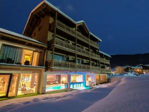 a large building in the snow at night at Francesin Active Hotel in Livigno