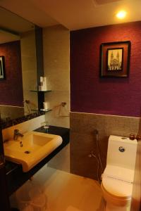 bagno con servizi igienici bianchi e lavandino di Biverah Hotel & Suites a Trivandrum