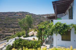 a white building with trees and a hill in the background at Agnanti Traditional in Kastron