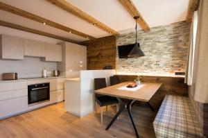 a kitchen and dining room with a wooden table at Appartment Hossler in Valdaora