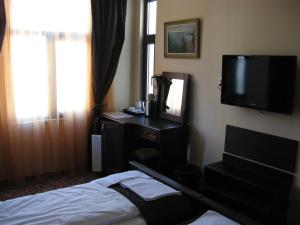 1 dormitorio con 1 cama, TV y espejo en Kapana Plovdiv, en Plovdiv
