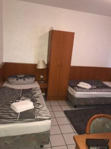 1 Schlafzimmer mit 2 Betten, einem Schrank und einem Tisch in der Unterkunft Lipmann am boll in Hamm