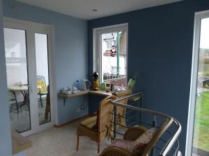 a room with a blue wall with chairs and a table at Hotel Holzhauer in Bad Wildungen