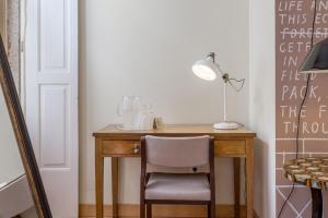 a desk with a chair and a lamp on it at The Poets Inn in Porto