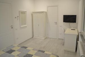 マリネッラ・ディ・サルザーナにあるZena Affittacamereの白い部屋(ベッド1台、シンク、テレビ付)