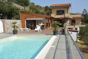 eine Villa mit einem Pool und einem Haus in der Unterkunft Villa Gemma di Mare in Santa Teresa di Riva