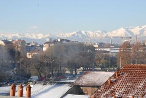 トリノにあるAppartamento Borgo Auroraの雪屋根・山を背景とした都市