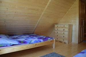 a bedroom with a bed and a dresser in a room at Ow Bursztynek in Rusinowo