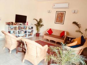 a living room with wicker chairs and a couch at The Neem in New Delhi