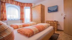 two beds in a room with a window at Haus Susanne in Neustift im Stubaital