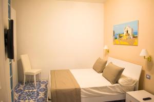 a small room with a bed and a chair at VILLA MARYLU' in Ischia Town
