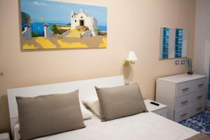 a bedroom with a bed and a dresser and a painting at VILLA MARYLU' in Ischia Town