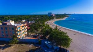 een luchtzicht op een strand en de oceaan bij Aparta Hotel Caribe Paraiso in Juan Dolio