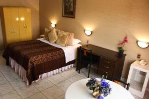 a hotel room with a bed and a table at Hotel Costa Pacifico in Arica