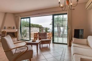 a living room with a couch and chairs and a fireplace at Villa Apostolata in Skala Kefalonias