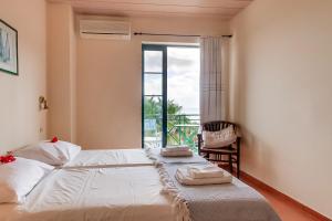 a bedroom with a bed with towels on it at Villa Apostolata in Skala Kefalonias +11 photos